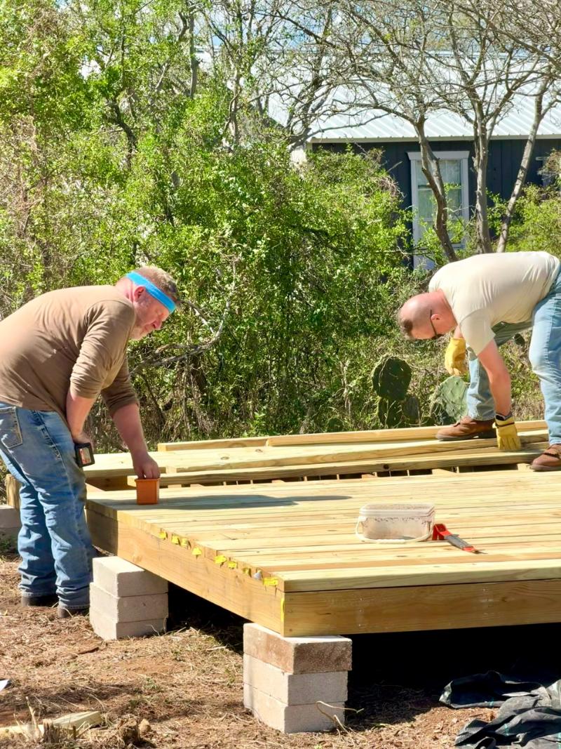 Volunteers laying deck boards on a finished platform